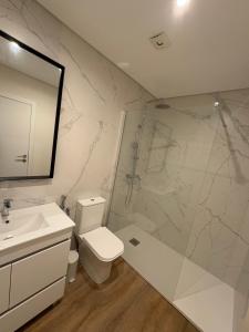 une salle de bains avec douche, toilettes et lavabo dans l'établissement Casa das Orquídeas Meco, à Sesimbra 10 autres photos