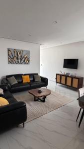 a living room with a couch and a coffee table at F3 2 Chambres Piscine Residence Point E in Dakar