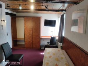 a room with a bed and a cabinet and a desk at Hotel Corveyer Hof in Höxter