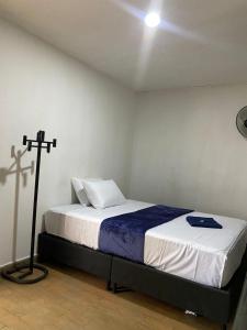 1 dormitorio con 1 cama con una cruz en la pared en Hotel el CONDADO, en Itagüí