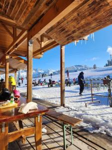 een houten paviljoen met mensen in de sneeuw bij SPOMAR One Bedroom Apartment in Bansko