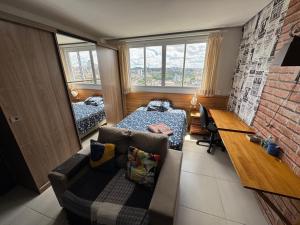 Fit Residence في بينتو جونكالفيس: غرفة نوم مع أريكة وسرير ومكتب