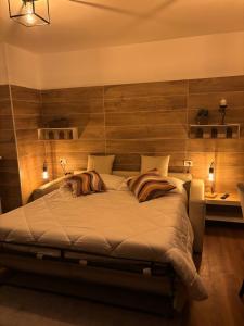 a bedroom with a large bed with a wooden wall at Apart Hotel Atlantic in Grado