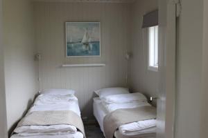 drie bedden in een kamer met een foto aan de muur bij Cabin in Mestervik in Meistervik