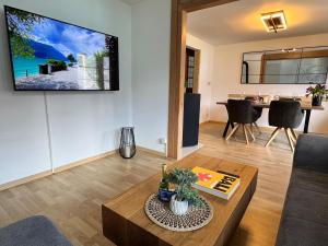 a living room with a tv on a wall at Breathtaking Lake & Mountain View Apartment 2 in Niederried +18 photos