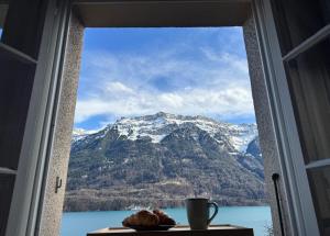 a window with a view of a snow covered mountain at Breathtaking Lake & Mountain View Apartment 2 in Niederried