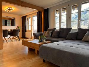 a living room with a couch and a table at Breathtaking Lake & Mountain View Apartment 2 in Niederried