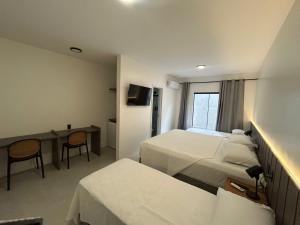 a hotel room with two beds and a desk at Belaris COMFORT - NOVA UNIDADE in São Luís