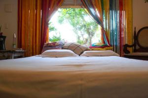 un letto grande in una stanza con una finestra di Casa Anéis de Saturno a Pipa