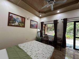 a bedroom with a bed and a table and a window at Trang An ViewPoint Homestay in Ninh Binh