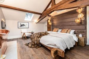 Un dormitorio con una cama grande con cabecero de madera. en 6 STAR, Brand New, Stunning Luxury Suites in a Characterful Historic Manor, Blending Timeless Charm with Modern Style! Welcome to the Old School Manor, Halkyn!!, en Halkyn