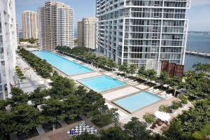 eine Draufsicht auf zwei Pools in einer Stadt mit Gebäuden in der Unterkunft Waterfront Spacious Luxury 1 Bedroom IconBrickell in Miami