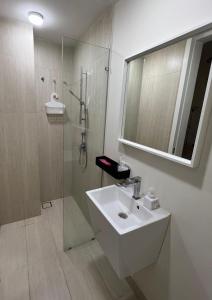 a white bathroom with a sink and a shower at Lumi Tropicana - Unique Stays ! in Kota Damansara