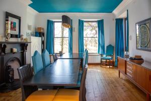 a dining room with a table and blue ceilings at St Marks Stays in Sedbergh