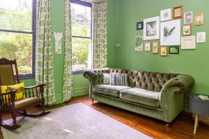 a green living room with a couch and a window at St Marks Stays in Sedbergh +66 photos