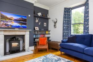a living room with a blue couch and a fireplace at St Marks Stays in Sedbergh