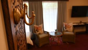 LUXURY FAMILY EN-SUITE ROOM @ 4 STAR GUEST HOUSE في ميدلبرغ: غرفة فندق بباب يؤدي إلى غرفة معيشة