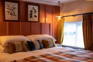 a bedroom with two beds and a window at The Filly Inn in Brockenhurst