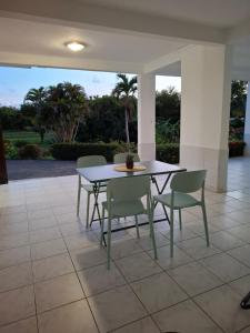 a table and chairs sitting on a patio at Logement chaleureux confortable - 2 chambres - Aveline in Petit-Canal