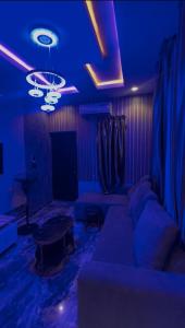 sala de estar con iluminación azul y sofá en Blue AO Service Apartment, en Lagos