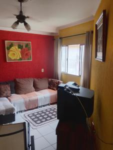 un soggiorno con un divano e un tavolo di Apartamento Recanto dos pássaros a Peruíbe