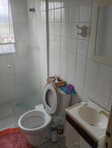 un bagno bianco con un water e un lavandino di Apartamento Recanto dos pássaros a Peruíbe