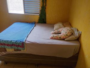 a small bed in a corner of a room at Apartamento Recanto dos pássaros in Peruíbe