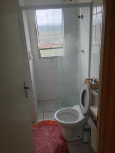 un piccolo bagno con servizi igienici e finestra di Apartamento Recanto dos pássaros a Peruíbe