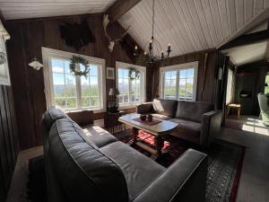 a living room with a couch and a table at Welcoming Cabin With Fireplace & Modern Kitchen in Beitostøl