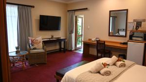 LUXURY FAMILY EN-SUITE ROOM @ 4 STAR GUEST HOUSE في ميدلبرغ: غرفة فندق بها سرير ومكتب