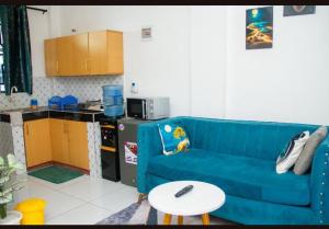 Pazuri Homes في متوابا: غرفة معيشة مع أريكة زرقاء وطاولة