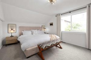 a white bedroom with a large bed and a window at Downtown location Near the Beach Dog Friendly in Edmonds