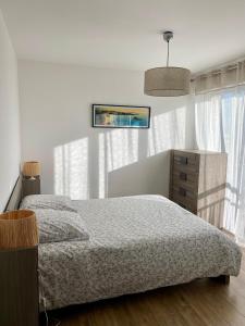 a bedroom with a bed and a large window at T3 - Centre - 75m2 - 2 SDB - Parking - Calme in Anglet