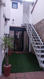 Private Loft Sant Celoni, Montseny, Barcelona في سان سيلوني: درج في منزل أبيض به نبتة