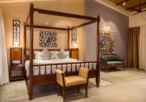 Parkwood Exotica Resort - Alibaug في Chorondpāda: غرفة نوم مع سرير بأربعة أعمدة وكرسي +32 صورة