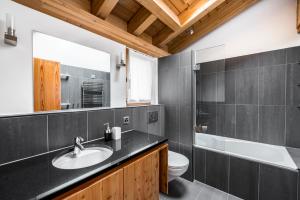 une salle de bain avec un lavabo, des toilettes et un miroir dans l'établissement Ari Resort Apartments, à Zermatt 95 autres photos
