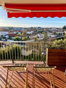 two chairs on a deck with a view of a city at T3 - Centre - 75m2 - 2 SDB - Parking - Calme in Anglet
