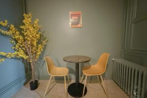 Una mesa y tres sillas en una habitación con una mesa. en L'Ecrin Balgentien - A deux pas de la Loire et du Centre, en Beaugency 40 fotos más