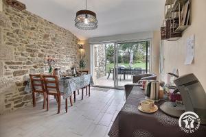 a kitchen and dining room with a stone wall at La croix au roi in Lamballe Armor