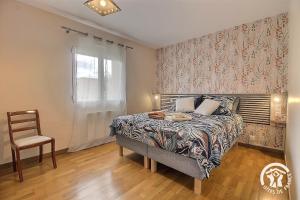 a bedroom with a bed and a chair and a window at La croix au roi in Lamballe Armor