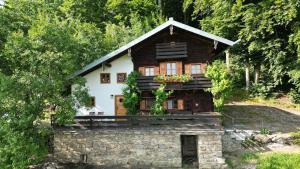 een klein houten huisje met een stenen muur bij Ferienhof Stetter in Schöllnach