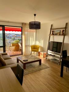 a living room with a couch and a tv at T3 - Centre - 75m2 - 2 SDB - Parking - Calme in Anglet