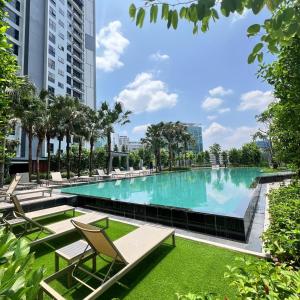 クアラルンプールにあるAgile Residence Bukit Bintang by Lumaの椅子と芝生と建物のある大きなプール