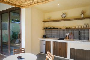 a kitchen with a table and a clock on the wall at Nala Villas in General Luna