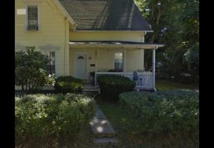 una vecchia casa gialla con un portico e un portico di Humble beginning a Norwich