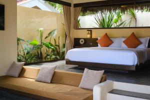 a bedroom with a large bed and a couch at Nala Villas in General Luna