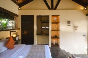 a bedroom with a bed and a clock on the wall at Nala Villas in General Luna