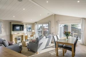 a living room with a couch and a table at Lodge 15 at Landscove Holiday Park in Brixham