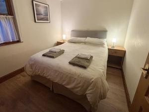 a bedroom with a bed with two towels on it at Morenish Mews Killin Cottage in Morenish