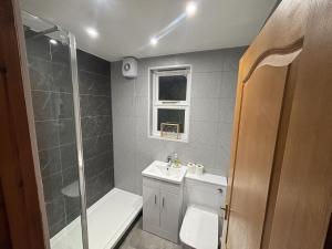 a bathroom with a shower and a toilet and a sink at Morenish Mews Killin Cottage in Morenish +24 photos